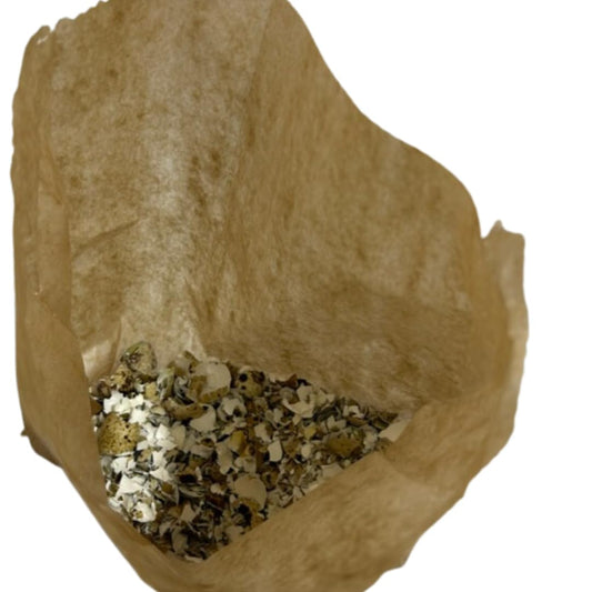 Close-up of Quail PlantShellz, natural plant nourishment product for houseplants, showing the packaging and plant in the background.