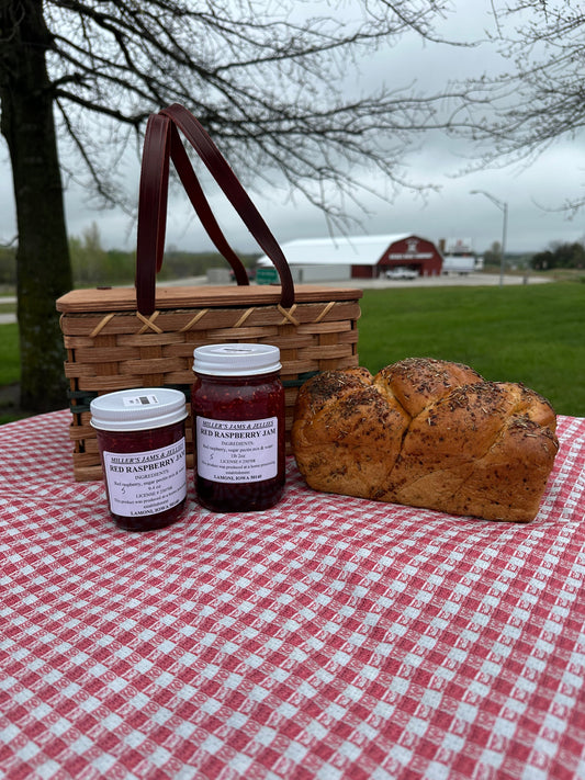 Amish Country Store Miller's Red Raspberry Jam jar with a red raspberry jam label on a wooden table