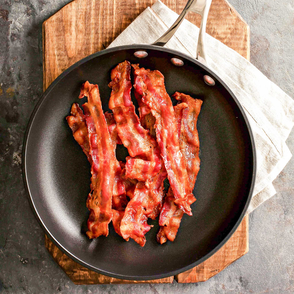 Pig of the Month BBQ Bacon Lover's Feast gift set featuring a variety of bacon cuts on a rustic wooden platter.