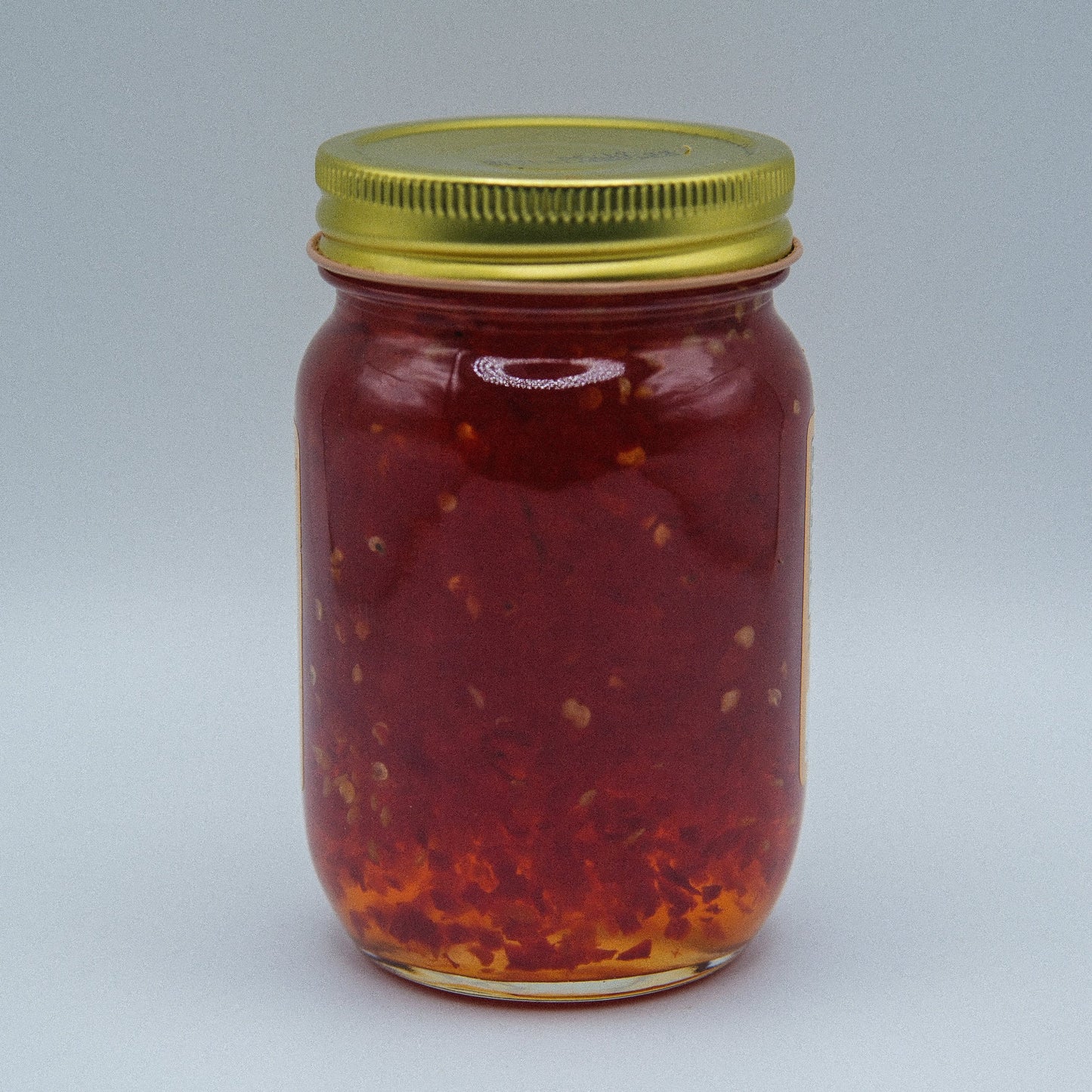 Amish Country Store hot pepper jam in an 18oz jar, showcasing vibrant red peppers and glossy jam texture in a canned goods container.