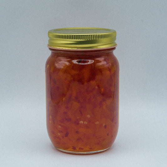 Canned Peach Jalapeno Jam in 18oz jar from Amish Country Store, showing the glossy peach and jalapeno jam in a clear glass jar.