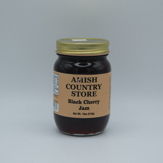 Canned black cherry jam in a jar from Amish Country Store, 18 oz, with a label showing fresh black cherries and jam texture.
