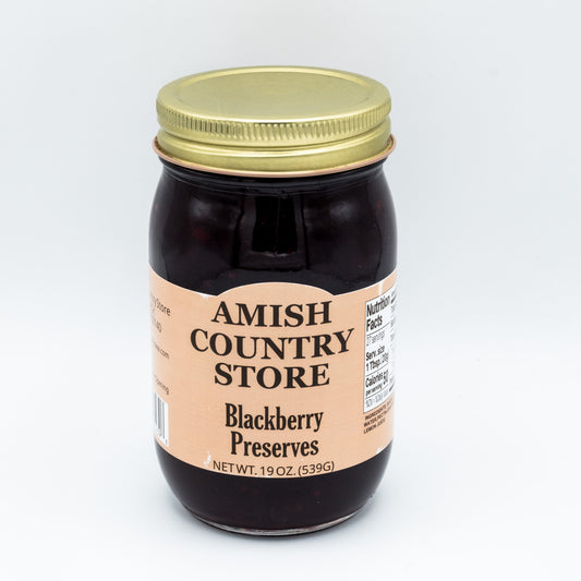 Canned blackberry preserves in a 16 oz jar by Amish Country Store, showing glossy blackberries and thick preserve texture.