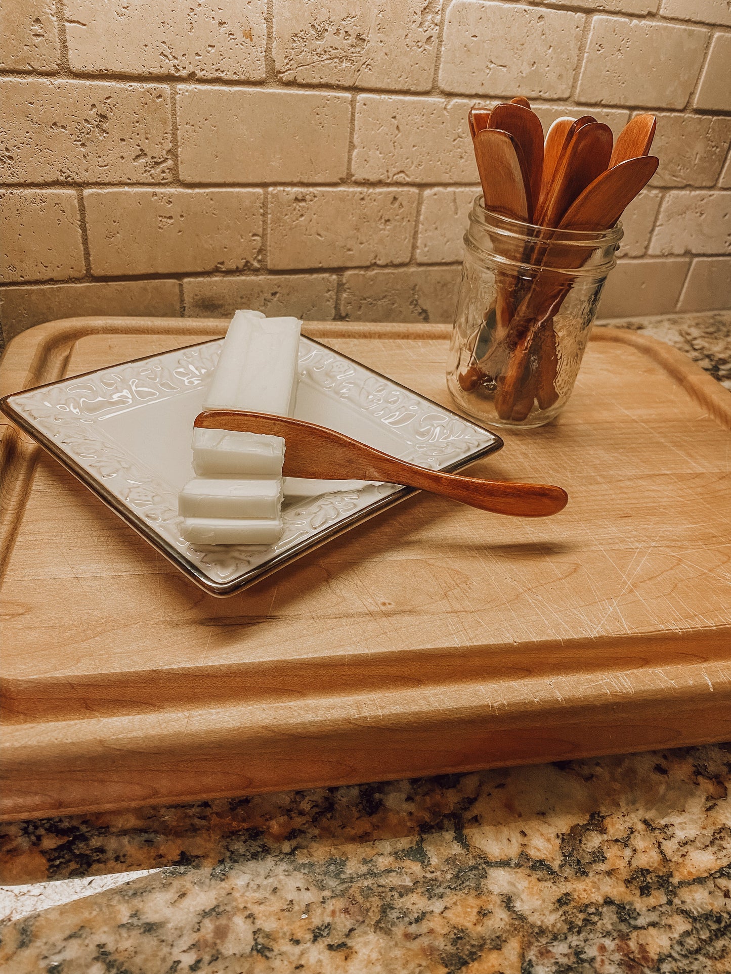 Onic Brands LLC wooden butter knife, merch product with a smooth wooden handle and butter spreading blade, displayed on a plain background.