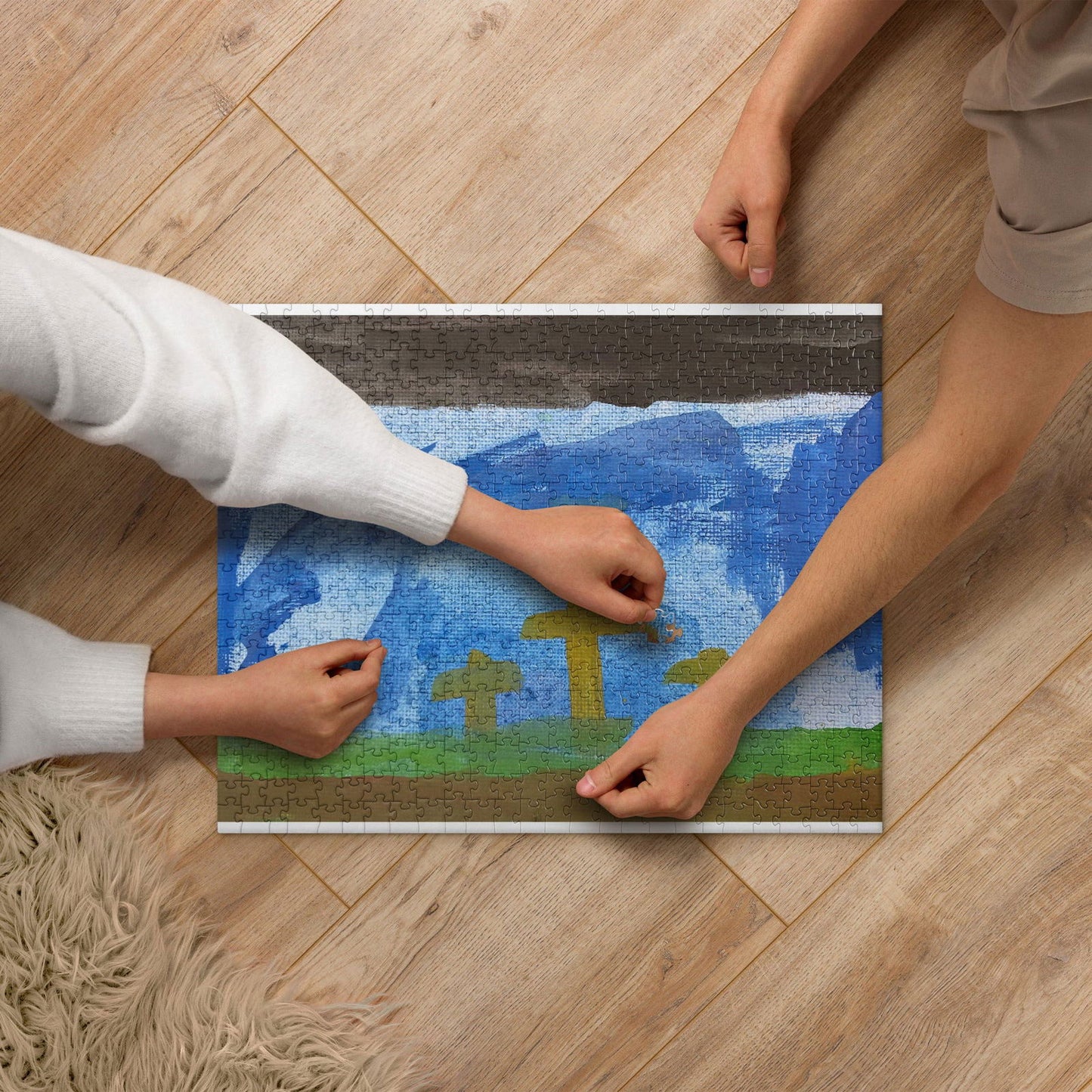Jigsaw puzzle depicting a childlike painting of a landscape with blue sky, green field, and yellow stylized trees, two people assembling it on a wood floor
