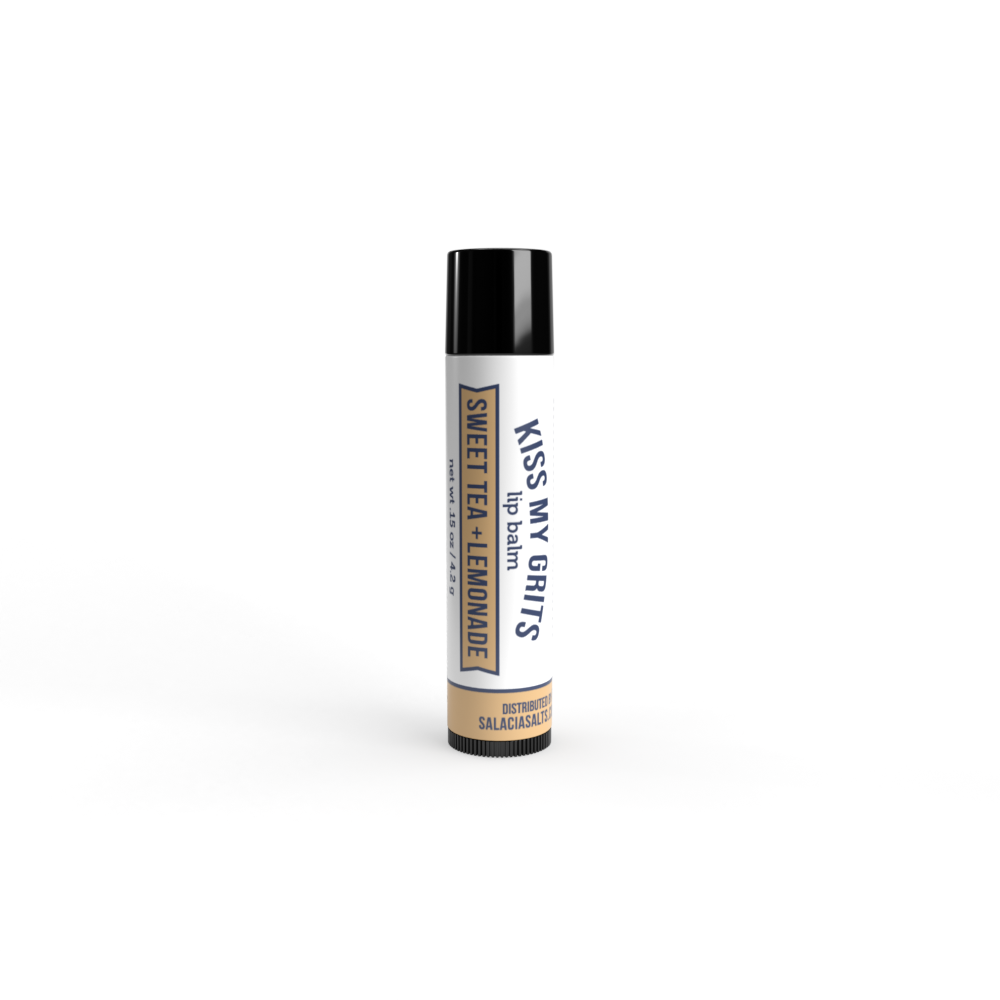 Salacia Salts’ Kiss My Grits Sweet Tea & Lemonade Lip Balm stands upright on a white background, featuring black, blue, and gold text with a black cap—a moisturizing treat for your lips.
