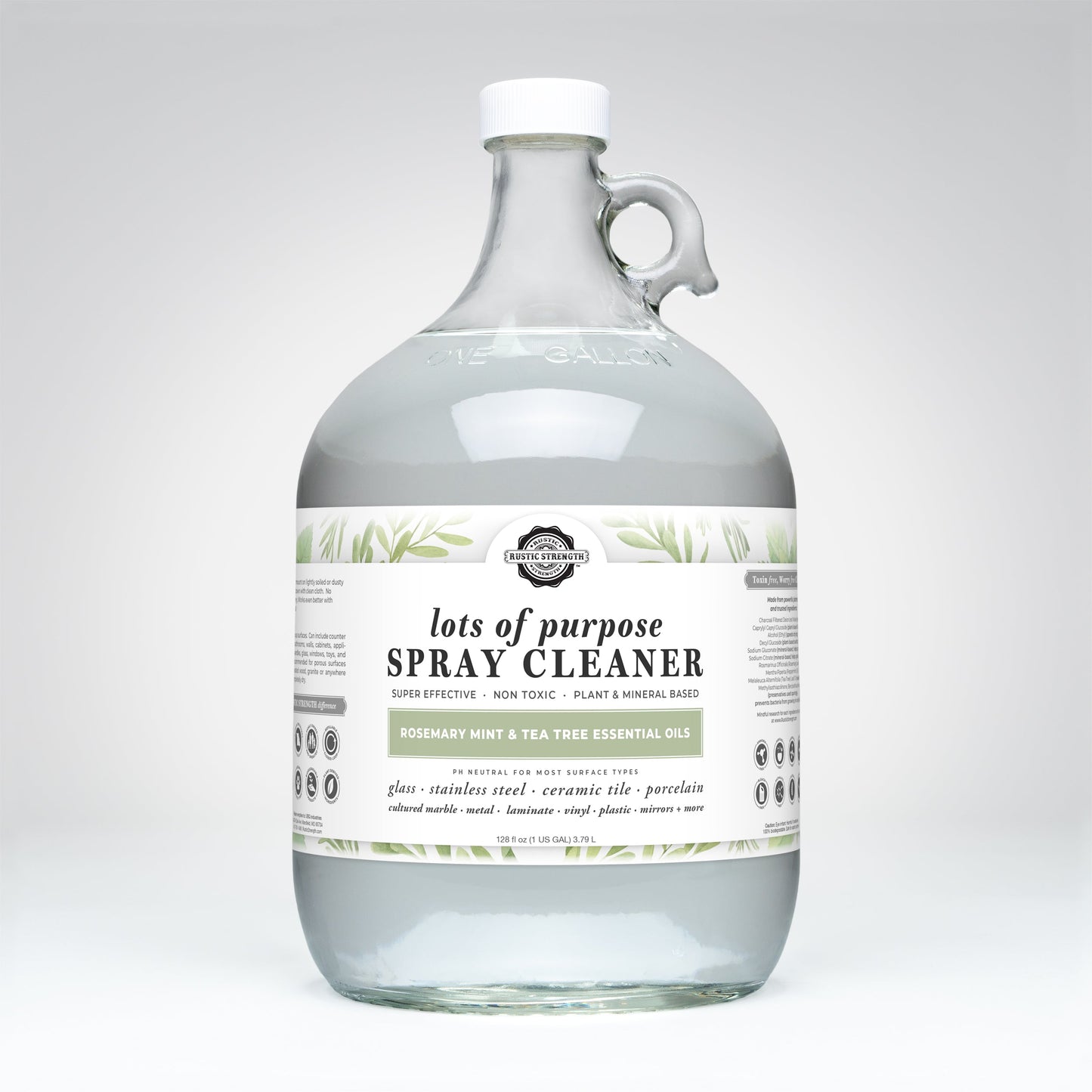 The Rustic Strength Lots of Purpose Spray Cleaner | Rosemary, Mint & Tea Tree is a toxin-free, plant and mineral-based cleaner in a clear one-gallon glass jug, featuring essential oils for natural cleaning.