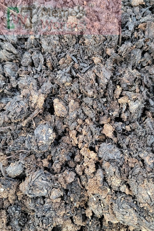 A close-up of Memes Worms Mushroom Compost shows a large pile of dark, crumbly, nutrient-rich material with a rough texture and earthy look.