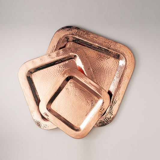 Set of Sertodo Copper Thessaly Square Platters with a hammered finish, ideal for serving food in a stylish, modern design.