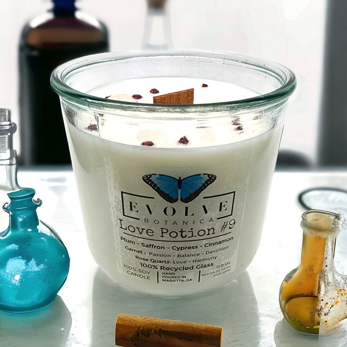 Evolve Botanica Rocks Candle Love Potion #9 with garnet and rose quartz gemstones, soy wax, and wood wick, in a decorative container.
