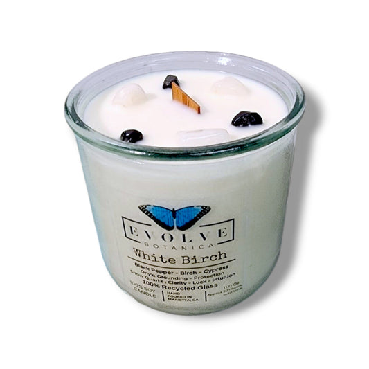 White Birch Rocks Candle by Evolve Botanica with wood wick, snow quartz, onyx gemstones, and soy wax in a decorative candle holder.