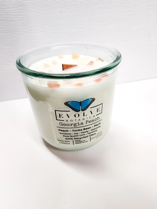 Evolve Botanica Georgia Peach Rocks Candle with a wood wick in a tumbler, featuring a gemstone design and peach scent.