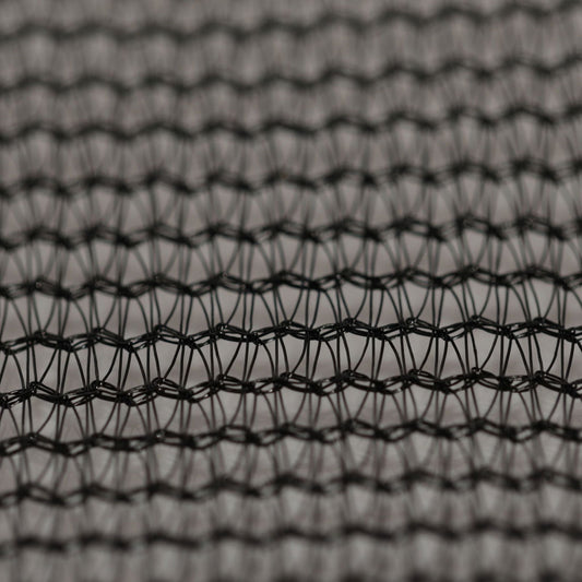 Close-up photograph of a dark grey woven textile with a complex interlaced pattern showing subtle shadows and highlights in its intricate network of fibers