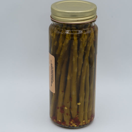 Jar of Amish Country Store hot pickled asparagus in a 16oz glass jar with peppers and spices visible.