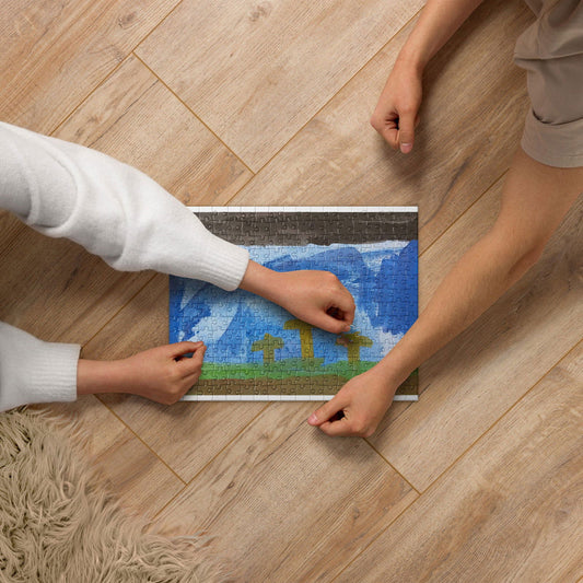 Jigsaw puzzle depicting a vibrant landscape with mountains and a blue sky featuring white clouds and green fields being assembled on a wooden floor by two people