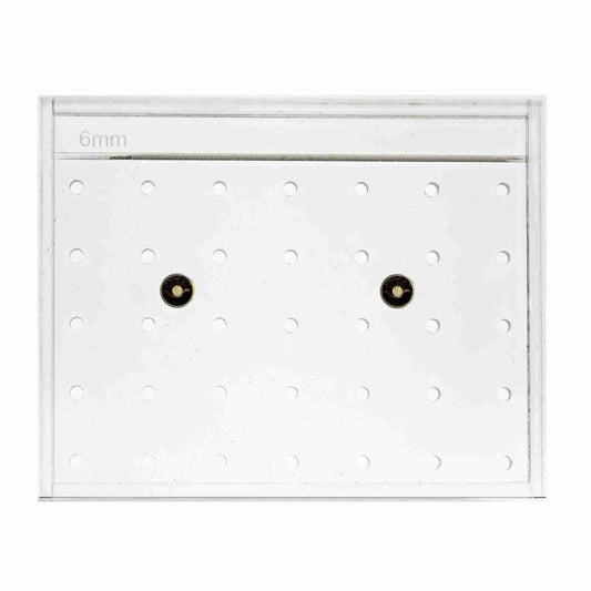 The Bootstrap Farmer Soil Block Drop Seeder - Standing 35 by Mindful Farmer is a clear, rectangular acrylic tool labeled 6mm, with evenly spaced grid holes and two central brass inserts.