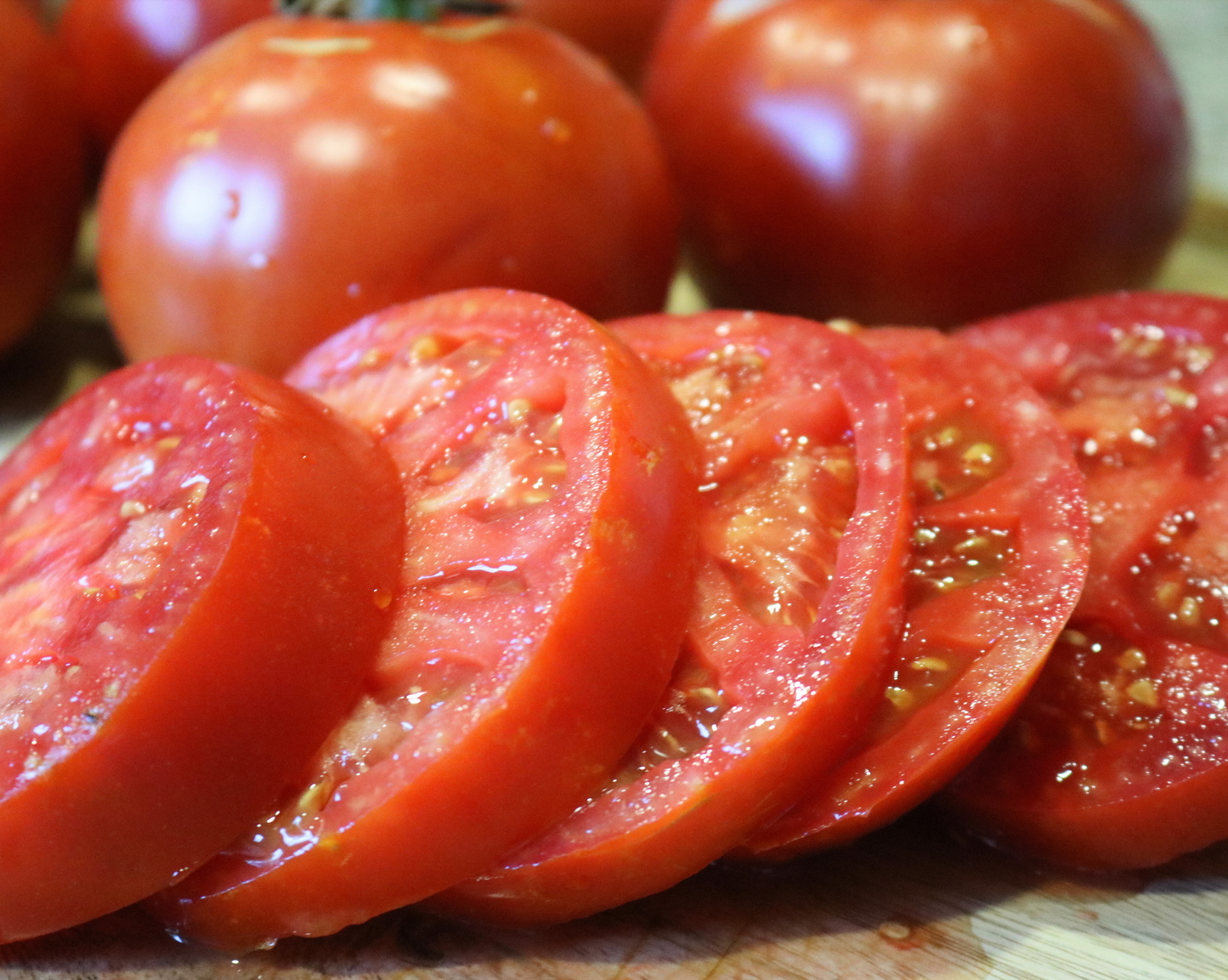 Burpee's Big Boy Hybrid tomatoes from Seeds 'n Such, known for their real tomato flavor and large size, are arranged on a cutting board.