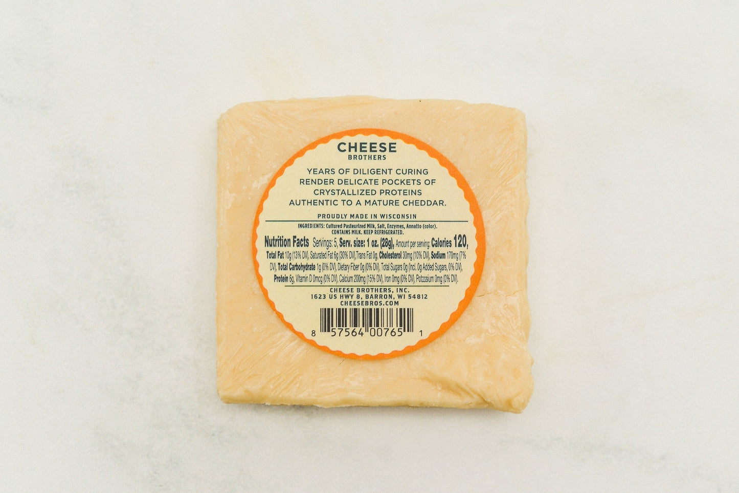 A block of 15-year-aged cheddar cheese from Cheese Brothers Inc., with a rich, firm texture and deep orange color.