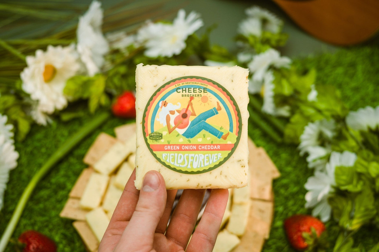 Slices of Green Onion Cheddar cheese from Cheese Brothers, Inc., showcasing vibrant green onions and rich cheddar texture.