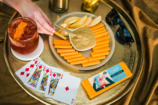 Slices of Pretty Boy Sharp Cheddar cheese from Cheese Brothers, Inc., showcasing its rich, firm texture and vibrant yellow color.