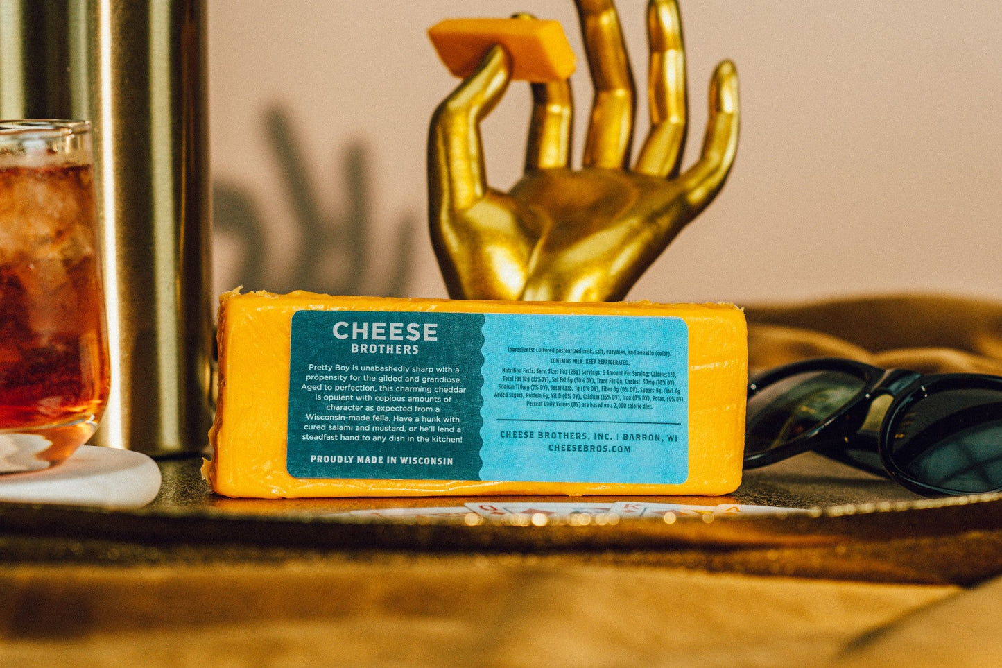 Slices of Pretty Boy Sharp Cheddar cheese from Cheese Brothers, Inc., showcasing its bright orange color and smooth texture.