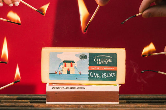 Smoked Cheddar cheese by Cheese Brothers, Inc., showing a block of rich, aged cheddar with a smoky flavor and smooth texture.