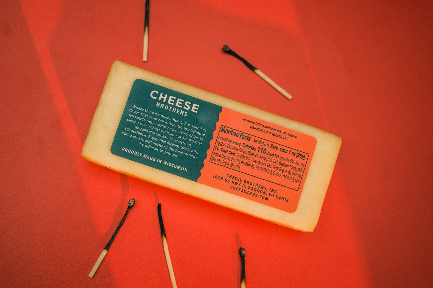 Smoked Cheddar cheese block from Cheese Brothers, Inc. with a rich, golden-brown exterior and smooth, firm texture.
