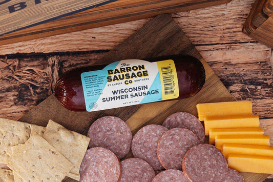 Slices of Barron Sausage Co. Summer Sausage, a cured meat product from Cheese Brothers, Inc., displayed on a wooden board.