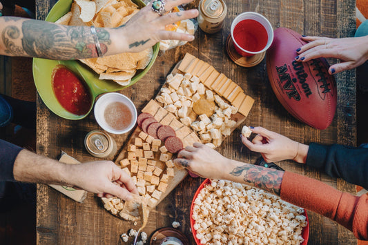 Deluxe Game Day Essentials Gift Pack by Cheese Brothers, Inc. includes snacks and party essentials for game day celebrations.
