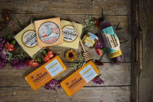 Cheese Brothers Inc. gift basket with assorted cheeses and snacks, themed "Hope You're Feeling Cheddar Soon" bundle for gift-giving.