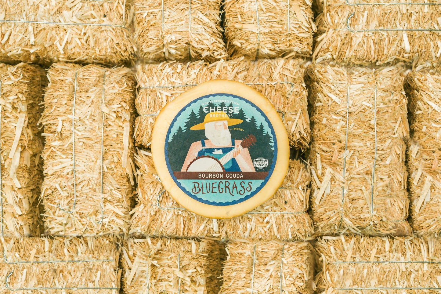 Bluegrass Bourbon Gouda cheese by Cheese Brothers, Inc., showing a wedge of smooth, golden Gouda with bourbon infusion.