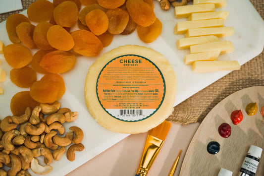 Wheel of Classic Gouda cheese from Cheese Brothers, Inc., showing smooth, golden-yellow surface with a firm texture.