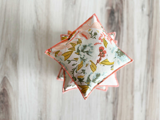 The Coral and Blue Lavender Sachets by Dot and Army, set of two, add a charming touch with their floral pattern and coral trim—perfect for freshening your drawers with the gentle scent of natural lavender.