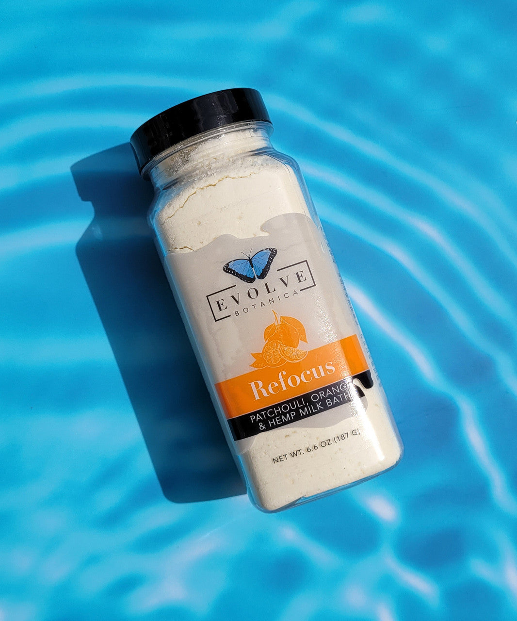 Evolve Botanica Milk Bath Refocus with patchouli, orange, and hempseed oil, showing a soothing milk bath container and natural ingredients.