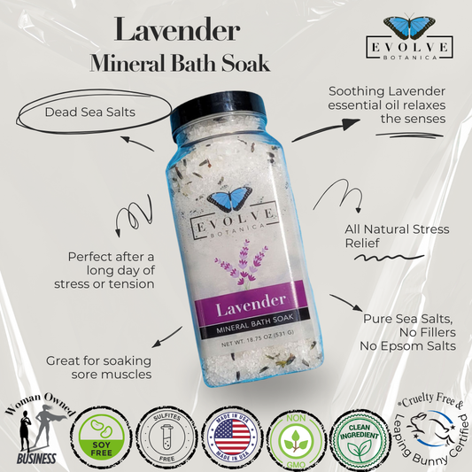 Evolve Botanica Lavender Spa Mineral Soak bath salt with calming lavender, in a clear glass jar with a wooden scoop.