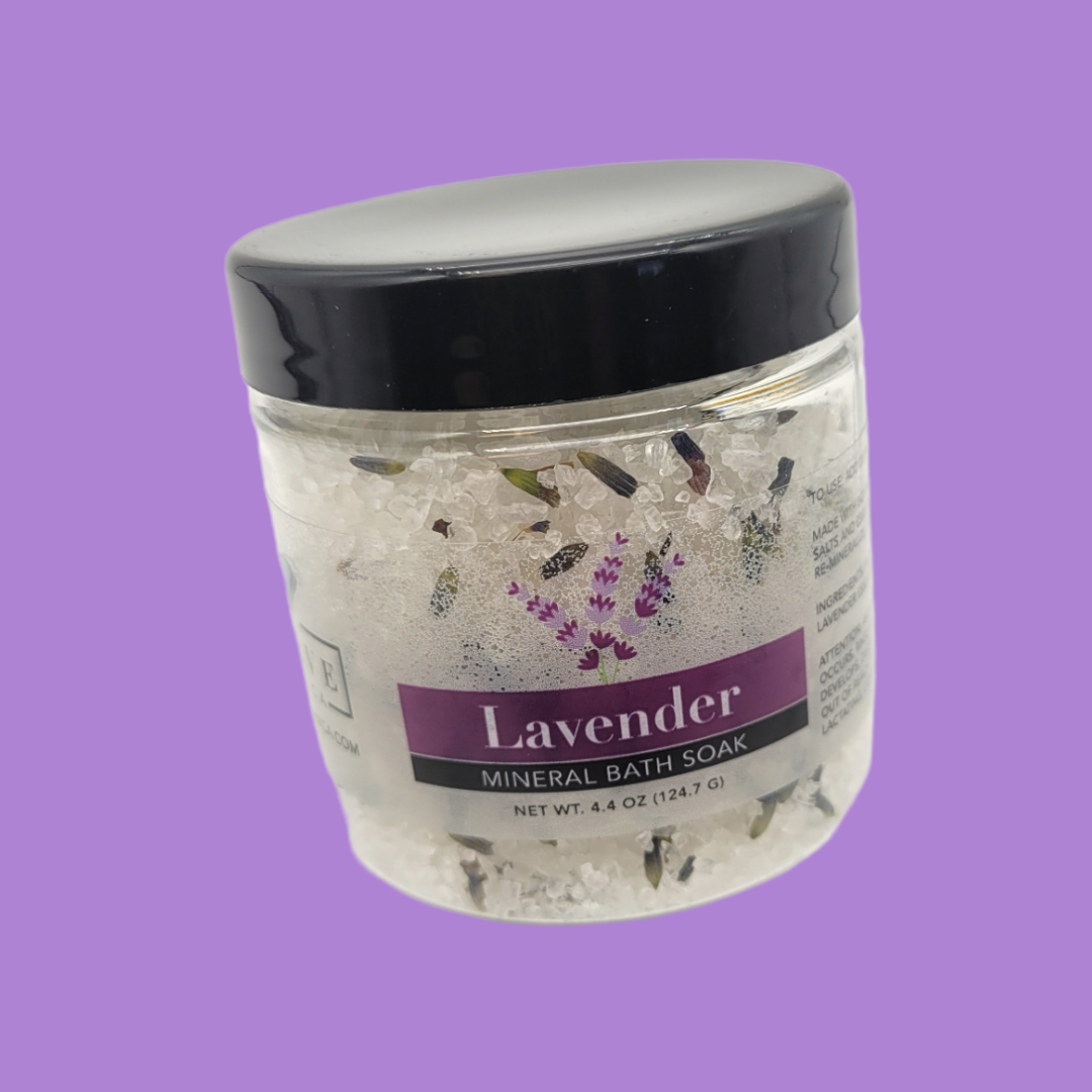 Evolve Botanica Lavender Spa Mineral Soak bath salt in mini size, showing a jar of lavender-scented bath salts with a relaxing spa setting.