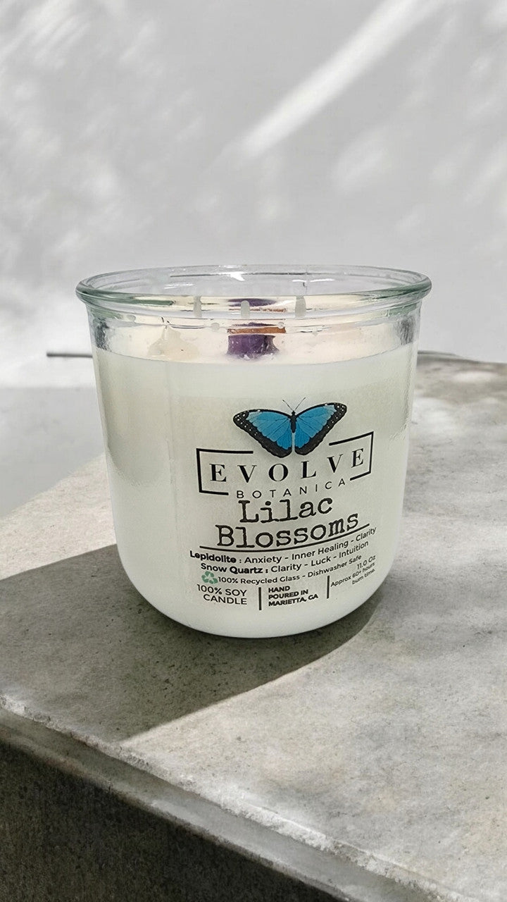 Evolve Botanica Lilac Blossoms Rocks Candle with wood wick, Lepidolite gemstone, soy wax, in a glass jar.