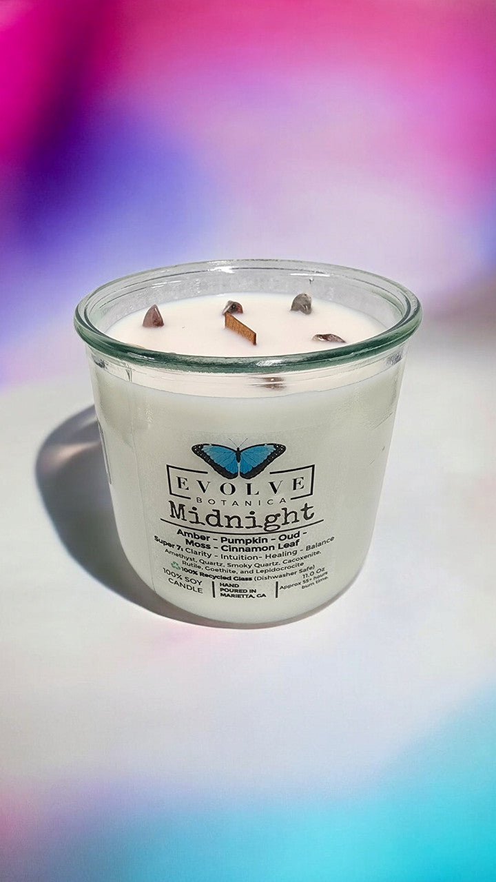 Evolve Botanica Midnight Rocks Candle with wood wick, featuring Super Seven gemstone soy wax in a sleek black jar.