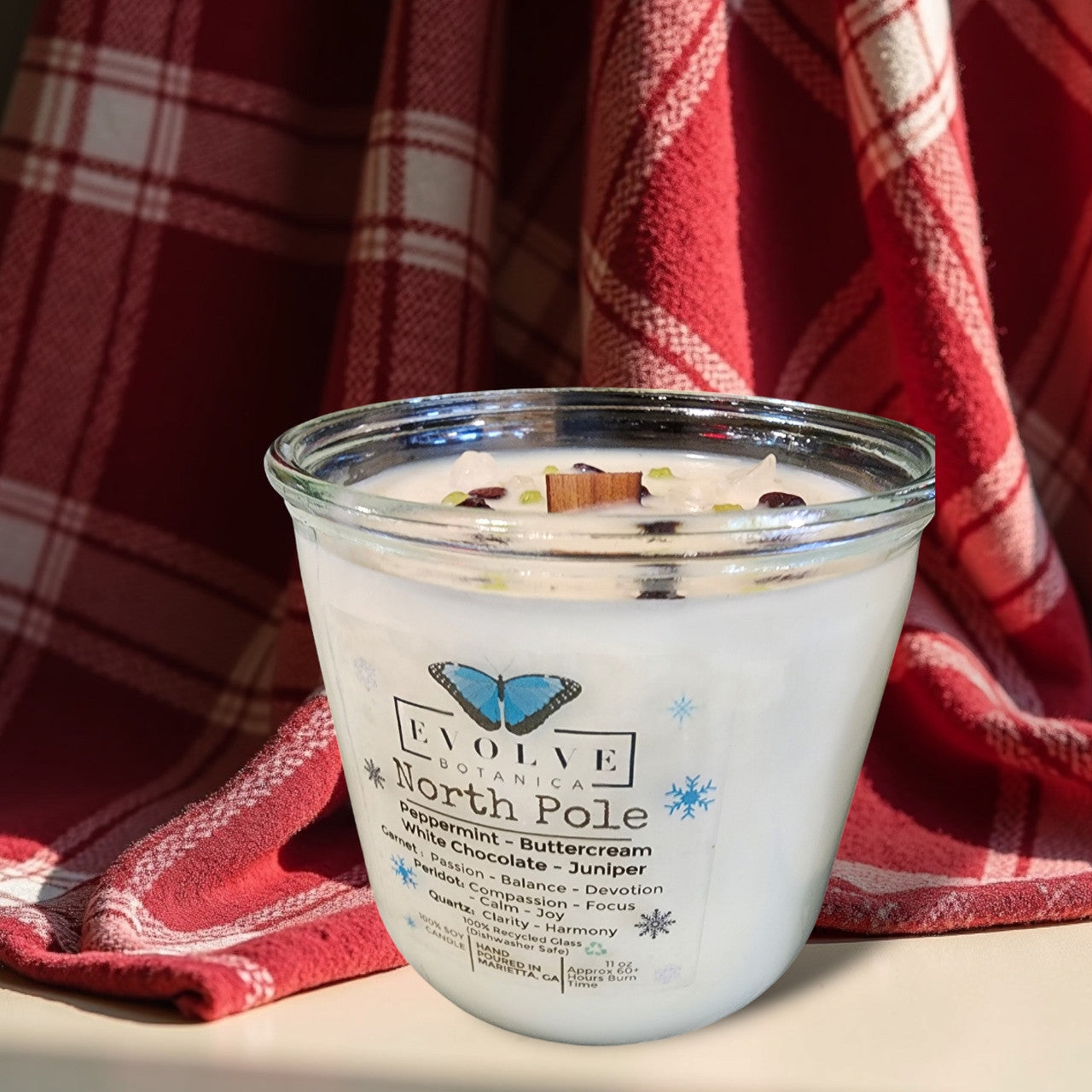Evolve Botanica North Pole Rocks Candle with wood wick, garnet, peridot, and quartz stones for passion, compassion, and harmony.
