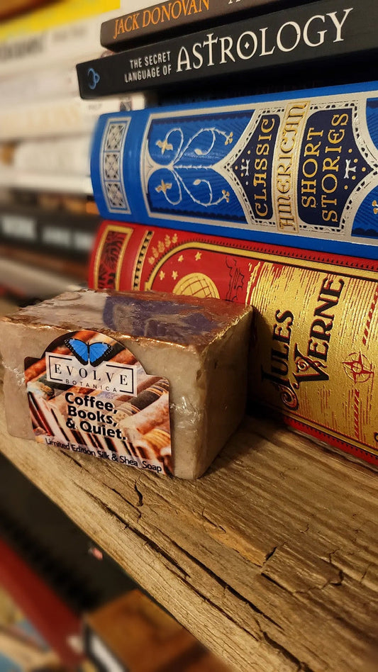 Limited edition Evolve Botanica specialty soap with coffee, book, and quiet-themed packaging, showcasing artisanal soap bars.