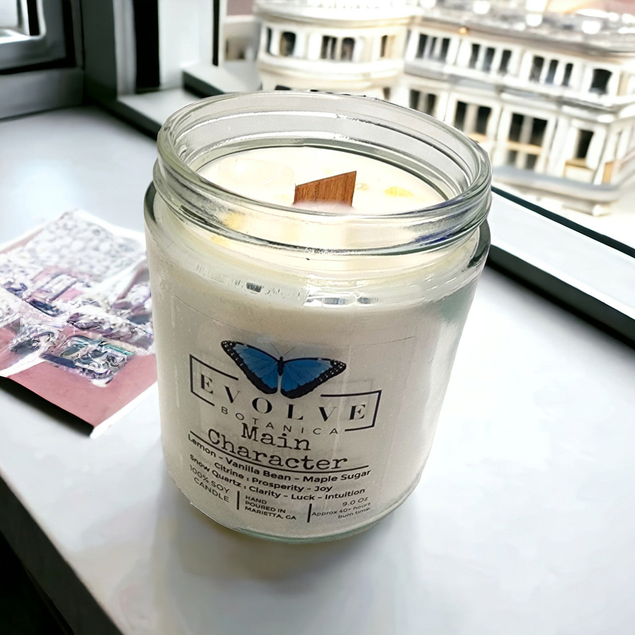 Evolve Botanica Classic 9oz jam jar soy candle with crystal accents, featuring Citrine and Snow Quartz for Main Character.