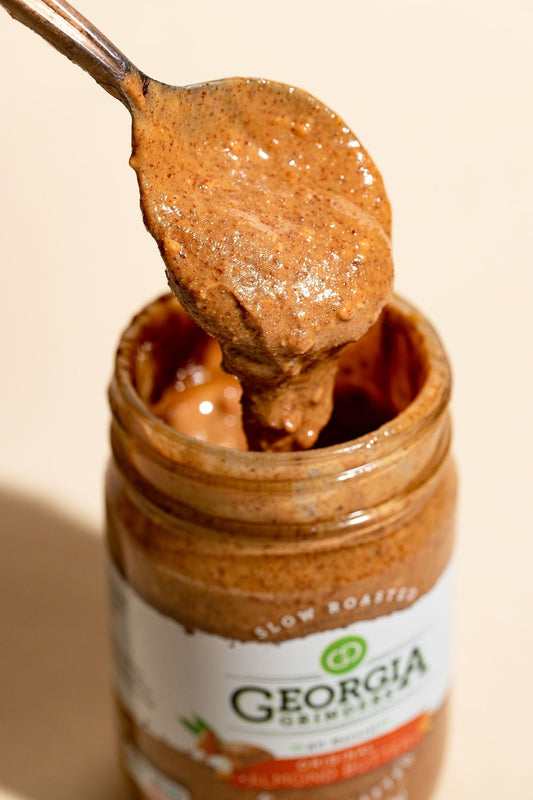 Four 12 oz jars of Georgia Grinders Original Almond Butter, creamy nut butter in clear jars with labels, arranged in a pack.