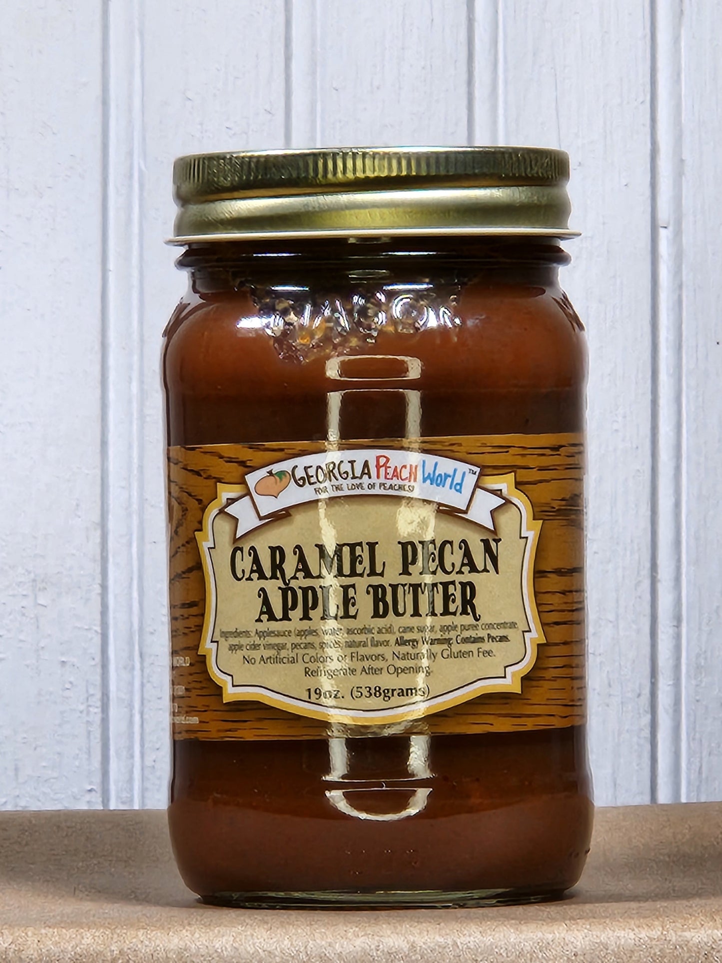 Creamy caramel pecan apple butter from Georgia Peach World, spread in a jar with caramel and pecan pieces visible.