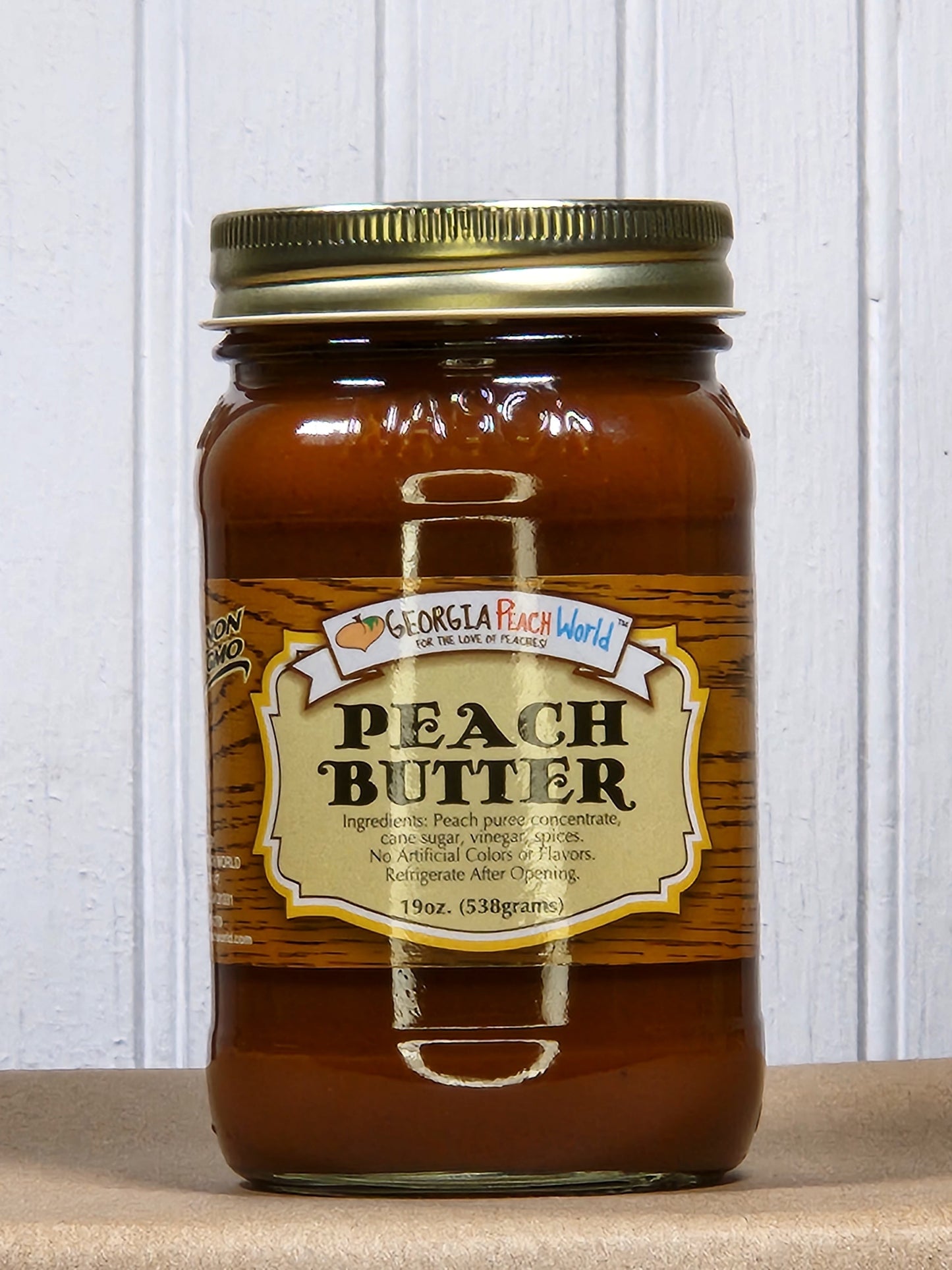 Jar of Georgia Peach World peach butter jam with golden peach spread on a white background