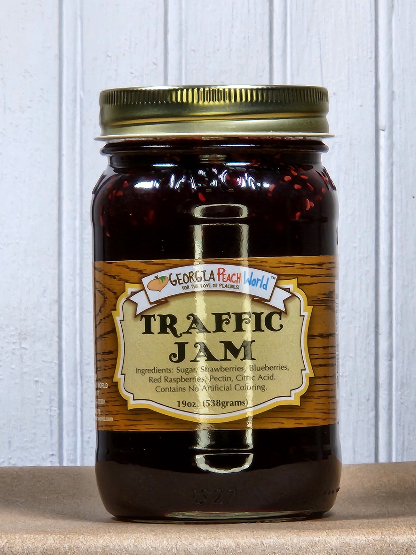 Jar of Georgia Peach World Traffic Jam made from ripe peaches with visible chunks and glossy, sticky texture.