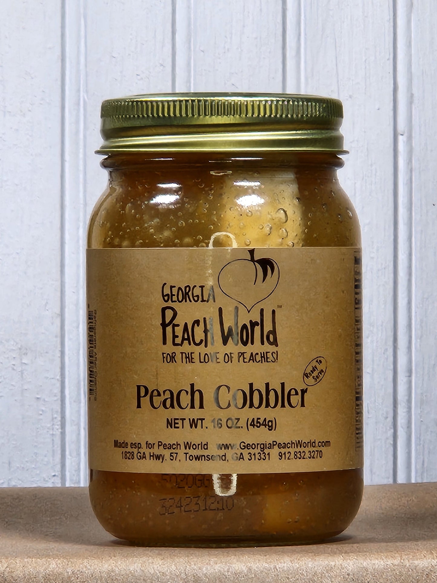 Georgia Peach World Peach Cobbler in a jar, a Southern treat with fresh peaches and baked crust, ready to enjoy.