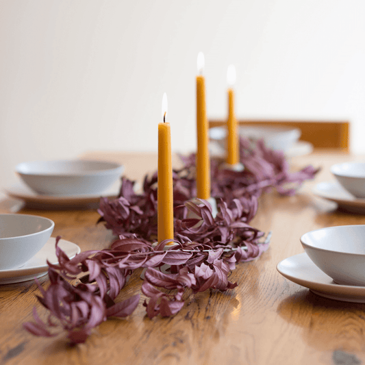 Hand-dipped beeswax taper candles in a bulk 4-pair bundle by Bluecorn Candles, shown with natural textured wax and wicks.