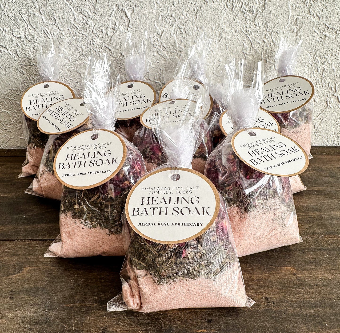 Herbalroseapothecary sore muscle herbal bath soak with Epsom salt, peppermint, and dried roses in a clear glass jar.