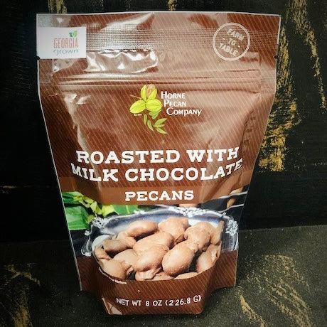 Horne Pecan Company roasted milk chocolate pecans in an 8 oz package, showing glossy chocolate-coated pecans on a white background.