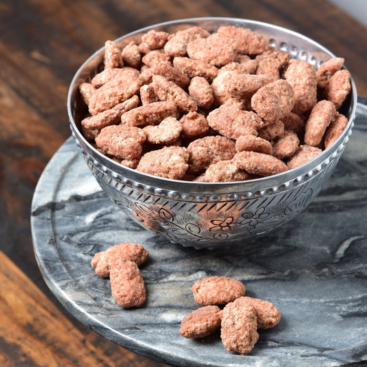 Praline-coated pecans from Horne Pecan Company, displayed in a clear bowl showcasing glossy, caramelized candy pecans.